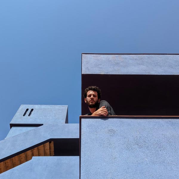 man looking down from balcony